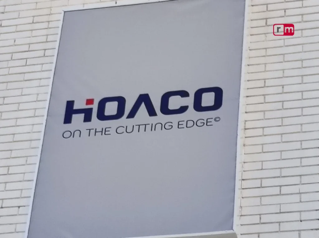 Rótulo de gran formato HOACO instalado en la fachada de un edificio, con la frase 'On the Cutting Edge'.